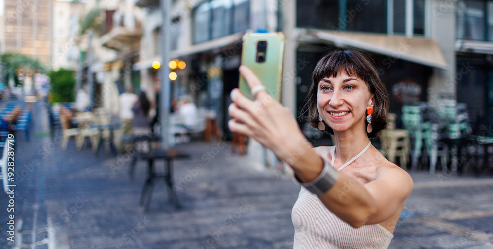 Photo portrait of a girl in casual clothes, smiling, walking along a city street, traveling on holidays and saying selfie. Photo portrait of a girl in casual clothes, smiling, walking along a city street, traveling on holidays and saying selfie.