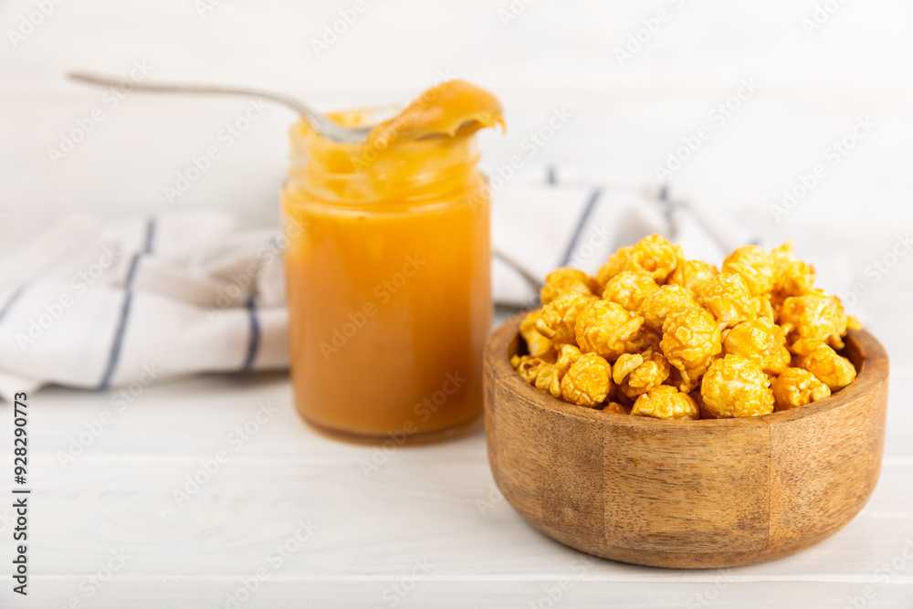Sweet caramel popcorn in a bowl on a wooden background. Salted caramel popcorn. Caramel sauce. Close up. Topping. Place for text. Copy space Sweet caramel popcorn in a bowl on a wooden background. Salted caramel popcorn. Caramel sauce. Close up. Topping. Place for text. Copy space