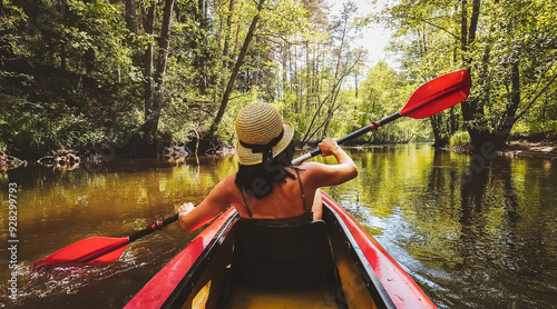 Back Rear View strong caucasian woman rowing Kayaking In Beautiful Lithuania countryside river - Zemeina. Action Camera POV Of Girl Paddling On canoe. Active holidays autumn or fall fun outdoors