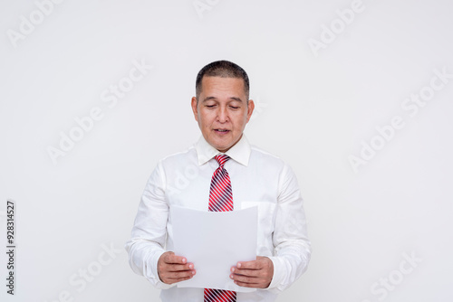 A middle aged asian manager reading some paper documents or reports. Isolated on a white background.