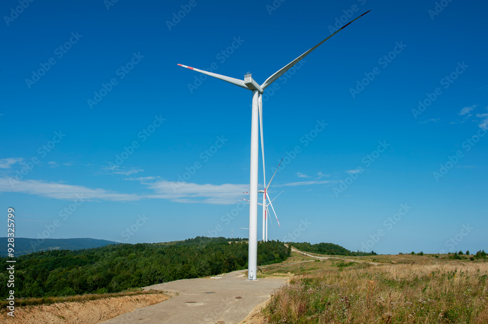 Wind turbines for clean energy production among blooming fields. Wind turbines for clean energy production among blooming fields.