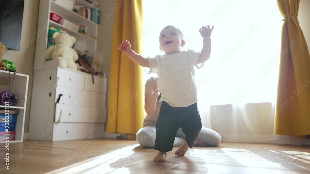 Parent helping child walk at home. Family enjoying fun moments together. Child learning to walk in sunlit room. Happy family bonding time. Parent supporting child. Family child fun at home. Family fun Parent helping child walk at home. Family enjoying fun moments together. Child learning to walk in sunlit room. Happy family bonding time. Parent supporting child. Family child fun at home. Family fun
