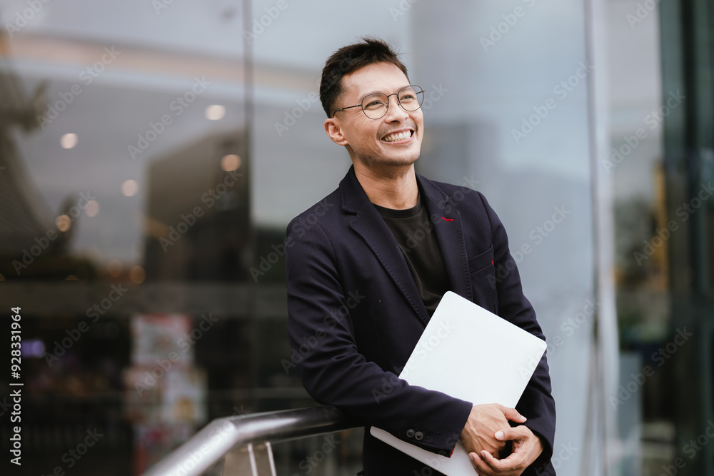 A determined young businessman in a city, confidently working on his laptop outdoors, dressed in a suit, embodying leadership, success, and motivation in the corporate world. A determined young businessman in a city, confidently working on his laptop outdoors, dressed in a suit, embodying leadership, success, and motivation in the corporate world.
