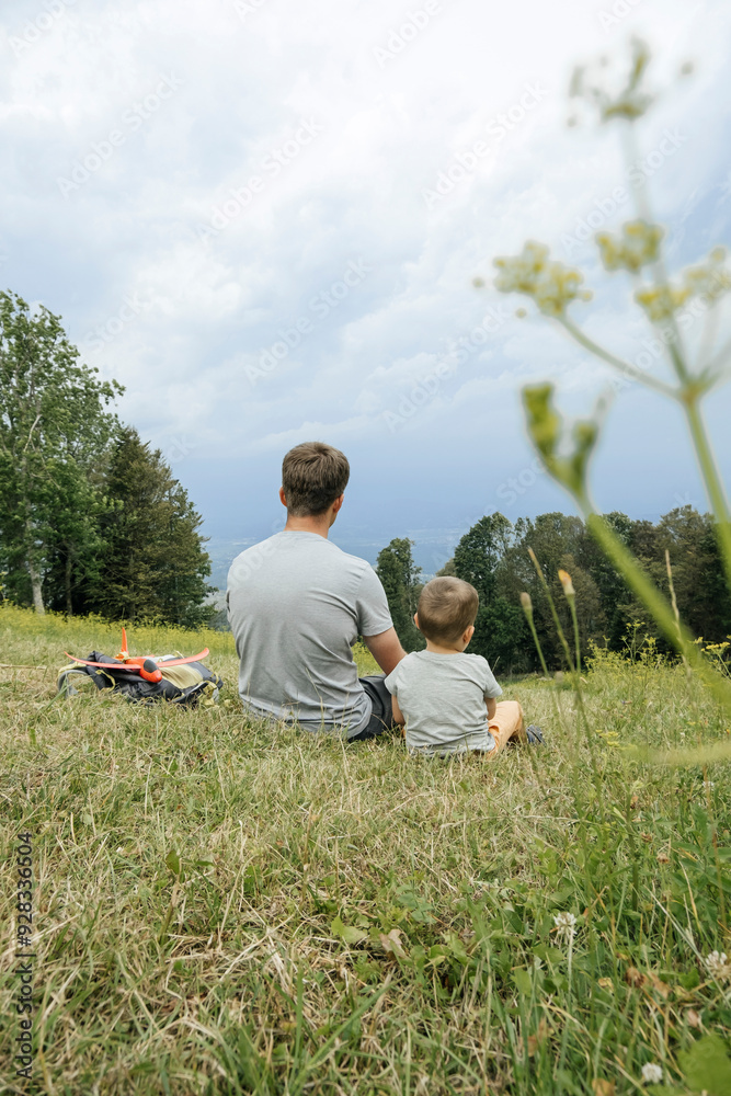 Father and son sitting together on grass Father and son sitting together on grass