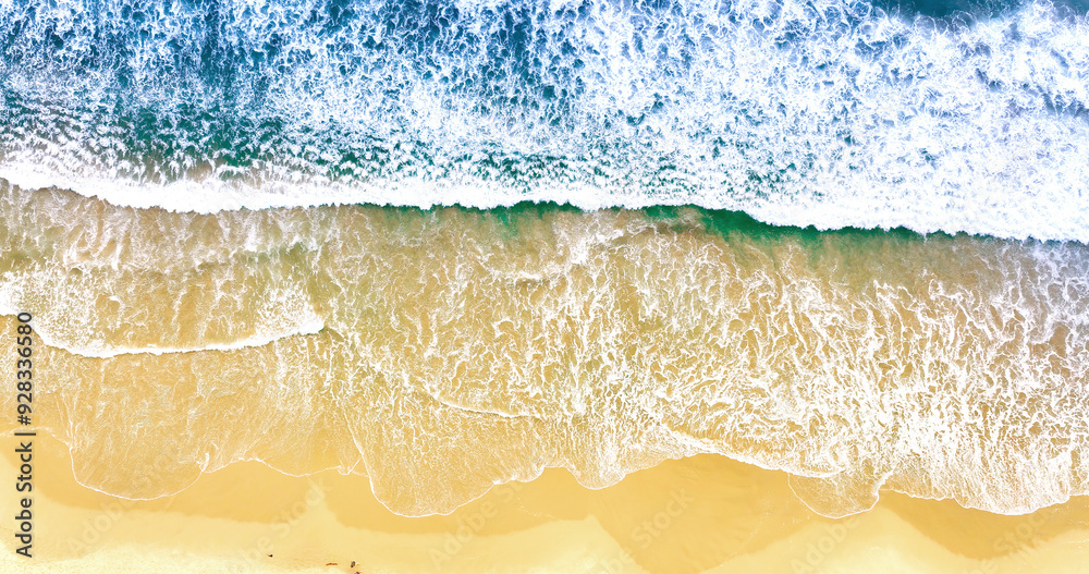 Sea waves and sand the summer background. Summer seascape beautiful waves, blue sea water. Top view from drone. Sea aerial view, tropical nature background. Sea waves splashing and beach sand.