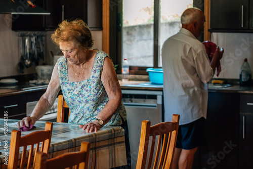 Фотография senior couple at home doing housework