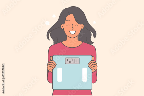 Woman shows scales after losing weight and smiles, rejoicing at good results from fitness and diet
