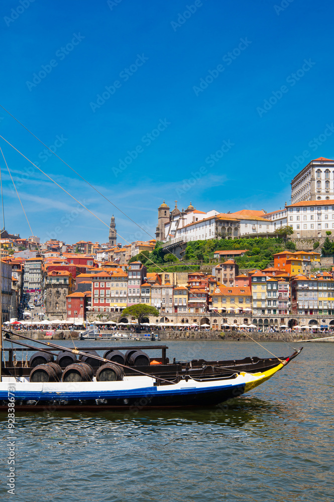 Obraz premium Cityscape of Porto (Oporto) over Douro River during a sunny day, Portugal. View of downtown Ribeira and embankment of Porto. Promenade view with colorful houses.
