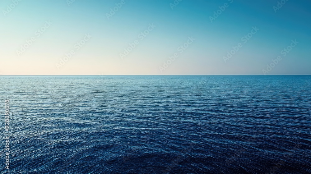 Obraz premium A panoramic shot of a blue sea with a distant horizon and a cloudless sky.