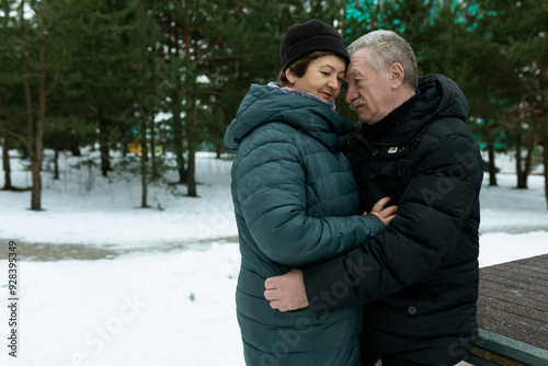 Happy elderly couple feels tenderness for each other while walking in the park