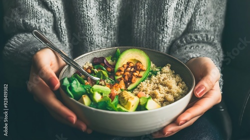 A close-up image showing a person's hands holding a bowl filled with a healthy salad, nutrition and healthy eating habits photo