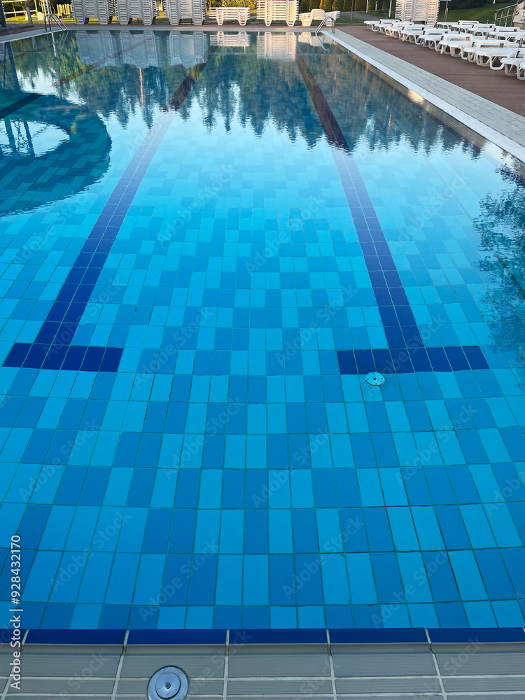Obraz premium Handrail stairs to the blue pool.Pool with stairs and water. Stainless steel stairs to the pool.