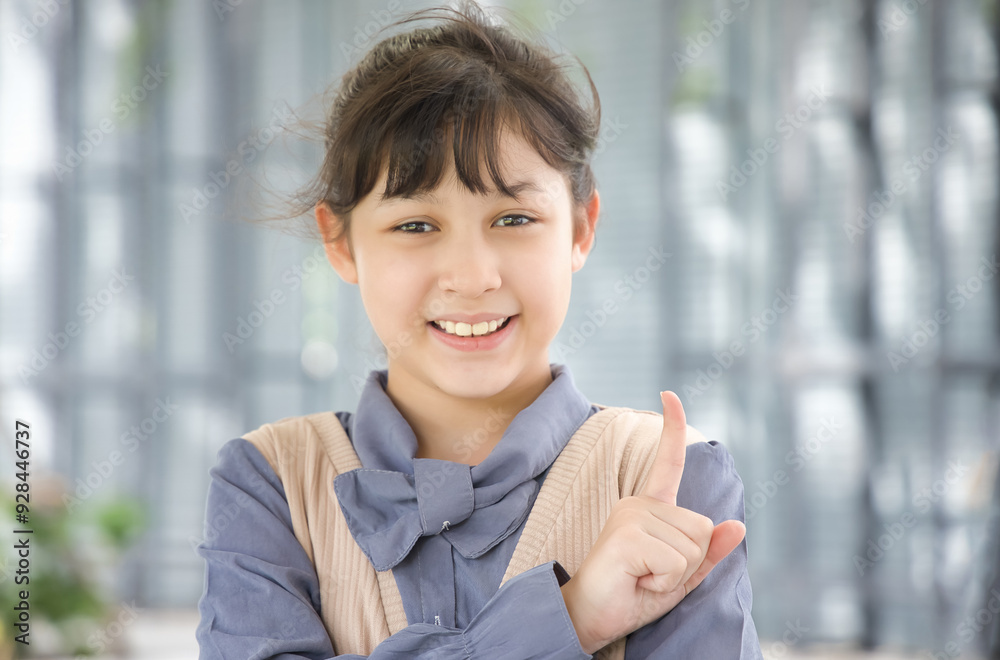 Happy smiling asian little girl looking pointing up one finger, number 1 counting gesture Happy smiling asian little girl looking pointing up one finger, number 1 counting gesture
