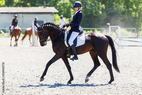 Young stressful teenage girl riding horse before her dressage test in equestrian competition