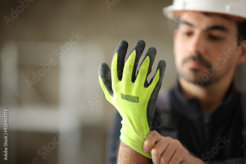 Construction worker putting protective glove before work photo