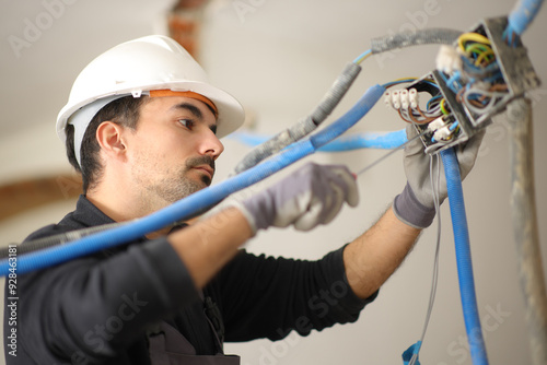 Electrician installing electrical system in a house under reform