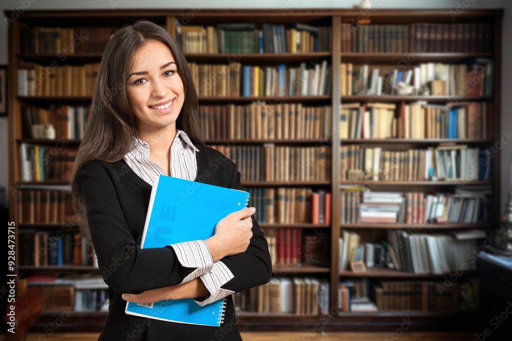 Happy young student in library with books Happy young student in library with books
