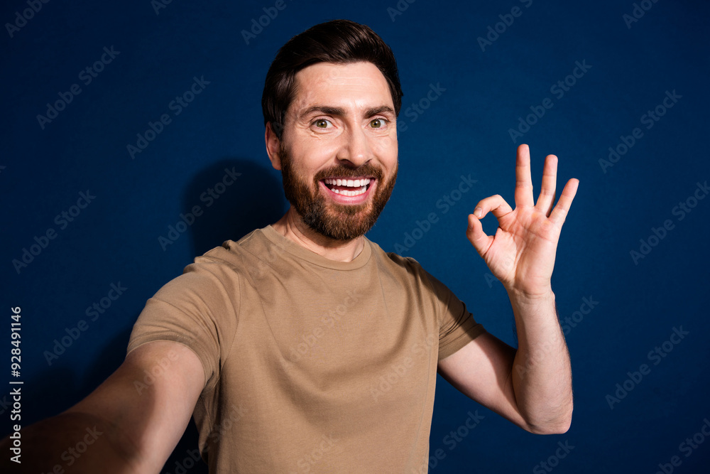 Photo portrait of young handsome guy brunet hair with stubble beard show okey isolated on dark blue color background Photo portrait of young handsome guy brunet hair with stubble beard show okey isolated on dark blue color background