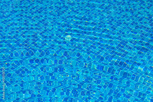 Blue and bright water surface with sun refection in swimming pool for background