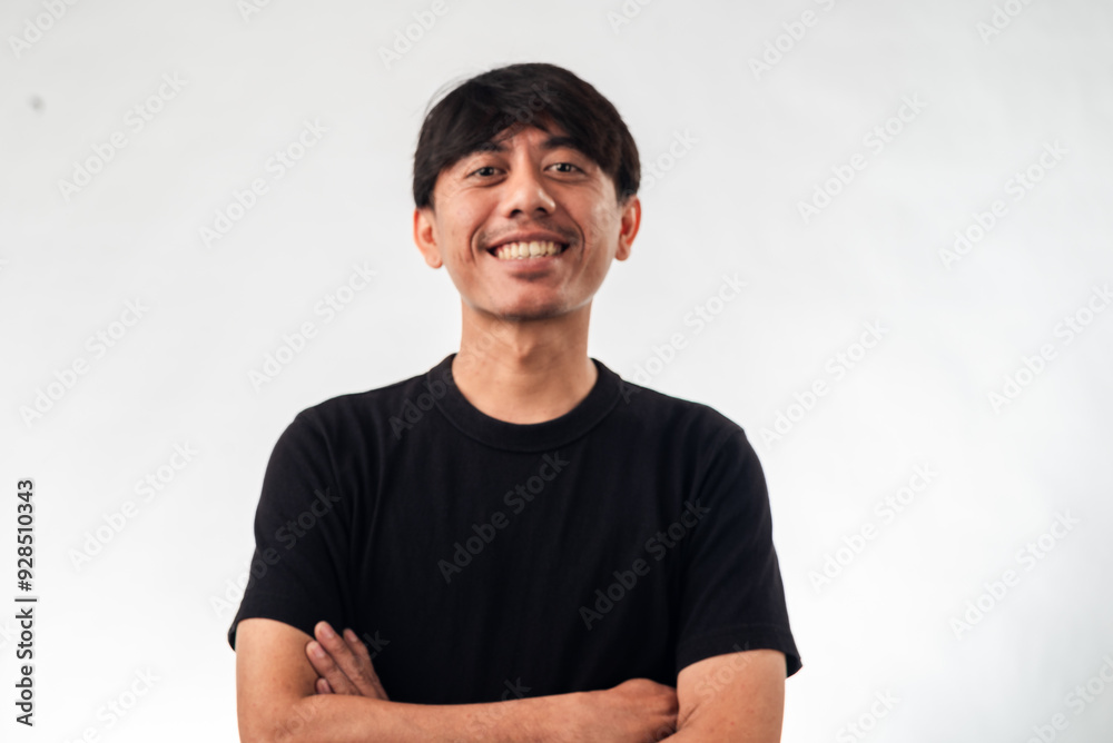 A smiling Asian man in a black t-shirt stands confidently with arms crossed against a plain white background, ideal for professional headshots, personal branding, or business profile content A smiling Asian man in a black t-shirt stands confidently with arms crossed against a plain white background, ideal for professional headshots, personal branding, or business profile content