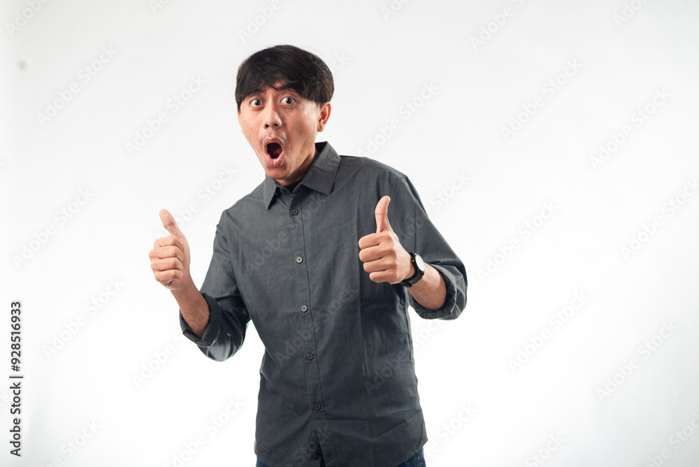 A cheerful Asian man in a dark grey button-up shirt gives double thumbs-up gestures against a plain white background, ideal for positive messaging, personal branding, or business profile content A cheerful Asian man in a dark grey button-up shirt gives double thumbs-up gestures against a plain white background, ideal for positive messaging, personal branding, or business profile content