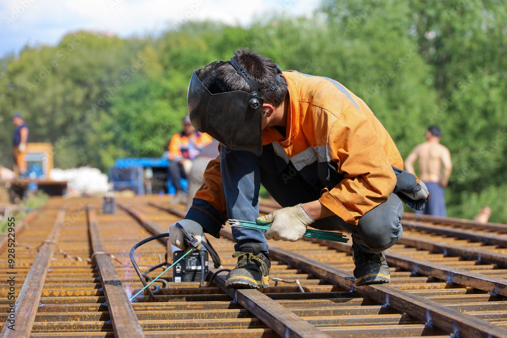 Welder working in the city. Construction worker on steel beams, welding works Welder working in the city. Construction worker on steel beams, welding works