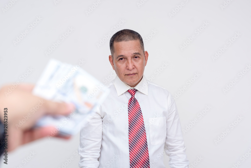 A middle aged professional ponders over taking a significant amount of cash. Potential bribery, payola or hush money. Isolated on a white background. A middle aged professional ponders over taking a significant amount of cash. Potential bribery, payola or hush money. Isolated on a white background.