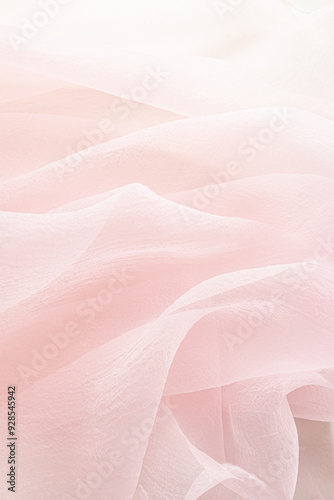 Abstract festive, wedding background with soft waves of chiffon fabric. Delicate pastel, beige, pink background. the texture of silk fabric. vertical.