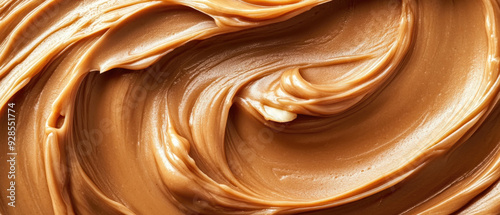 Close-up of creamy peanut butter swirls with scattered peanuts, showcasing the texture and color contrast in an extreme close-up shot.