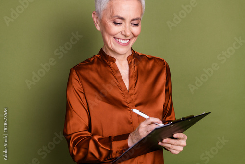 Photo portrait of pretty retired female write paperholder sign document wear trendy brown formalwear isolated on khaki color background photo