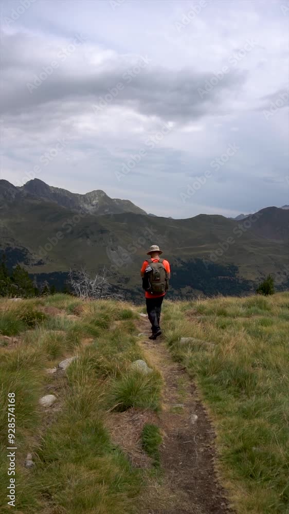 Slow motion, person walking in the mountains. Back view Slow motion, person walking in the mountains. Back view