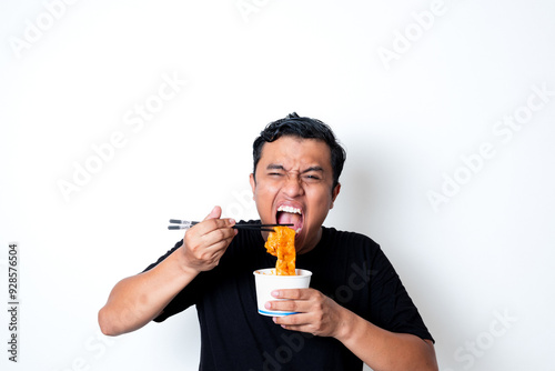 Asian adult man wearing a black t-shirt posing eating Korean specialty food odeng isolated white background photo