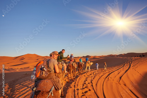 Tourists riding camels, smiling, in the Sahara Desert