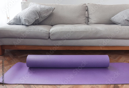 Purple yoga mat on the floor in a room with a bed