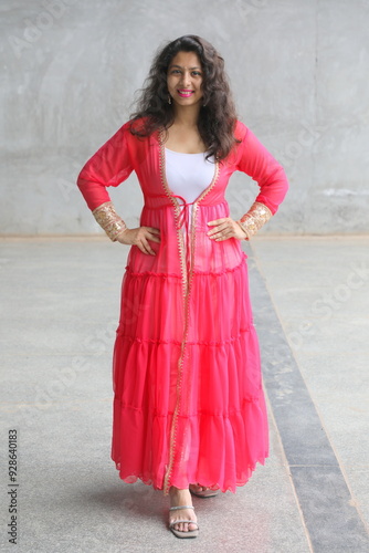 indian model wearing indo western ruffle shrug full of frills. she is standing in a style to showcase the outfit. Designer ethnic pink georgette jacket with golden borders for indian festive occasions