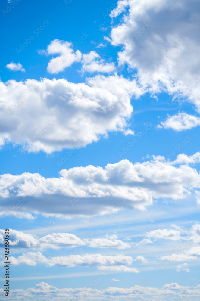 Fototapeta premium Blue sky landscape with white evening sky clouds lit by sunny, blue sky background