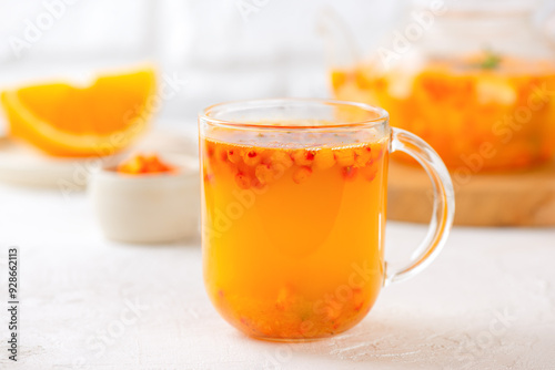 Hot sea buckthorn tea with orange, ginger and cinnamon in glass cups. Herbal vitamin c tea.