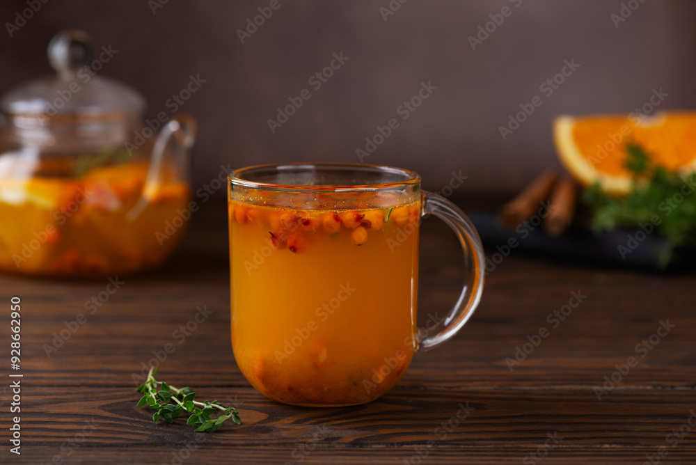 Sea buckthorn autumn tea with orange, thyme and cinnamon in glass cups on wooden table. Herbal vitamin tea. Sea buckthorn autumn tea with orange, thyme and cinnamon in glass cups on wooden table. Herbal vitamin tea.