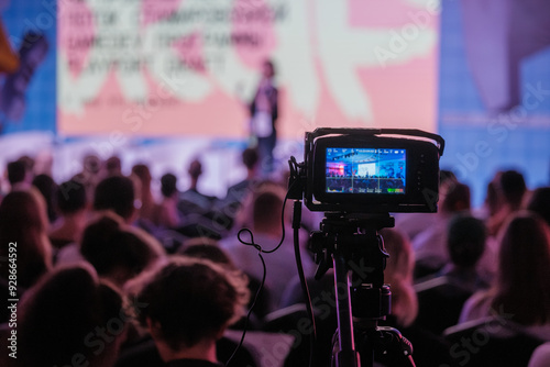 Wallpaper Mural Video camera records live conference attended by audience in auditorium, capturing event for streaming or archival purposes. Torontodigital.ca