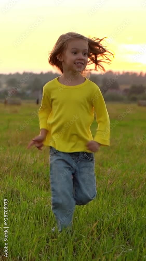Camera movement on little girl runs and laughs across field with haystacks at sunset. Happy child outdoors. Countryside, village and agriculture. Vertical shot Camera movement on little girl runs and laughs across field with haystacks at sunset. Happy child outdoors. Countryside, village and agriculture. Vertical shot