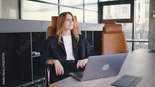 In a modern office, a dedicated professional female diligently works at her stylish desk with her laptop, striving to achieve excellence in her career and meet her goals effectively. Woman finishes
