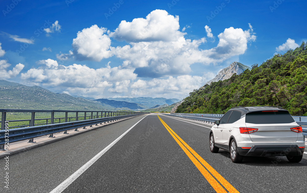 The car is driving along the highway surrounded by picturesque nature.