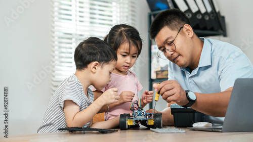 Canvas Print A boy and girl are learning to build robot toys with their dad in the living room