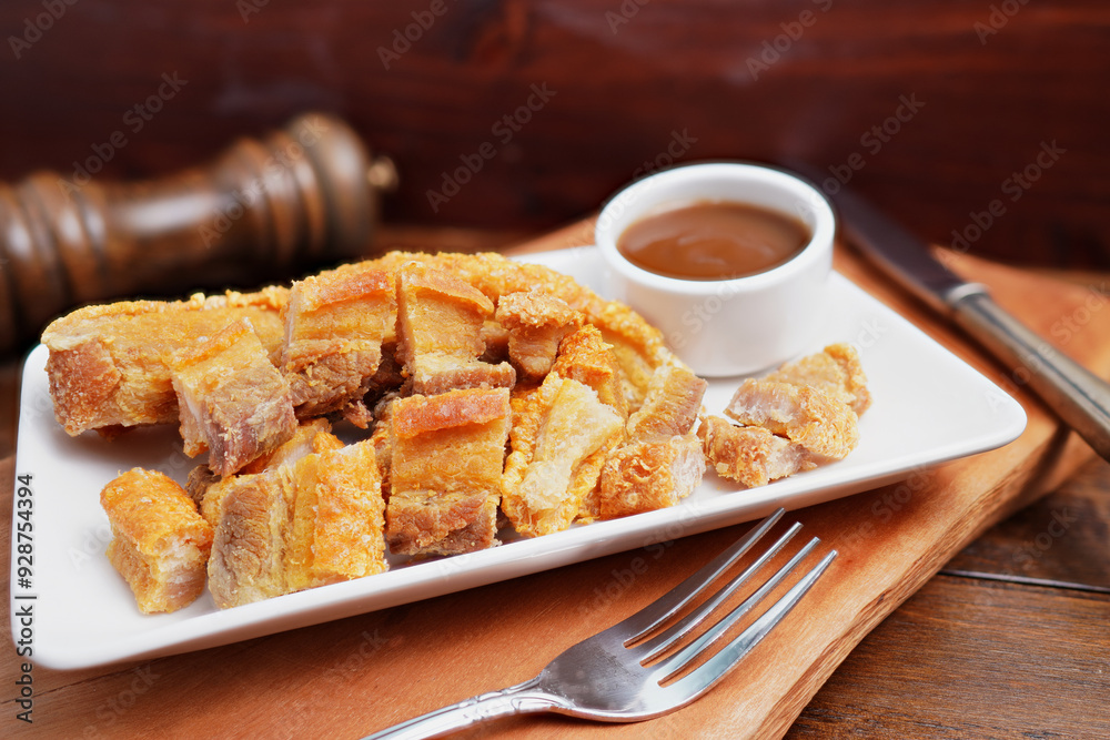 Thai food. Crispy fried pork belly cut into pieces on a wooden table. Thai food. Crispy fried pork belly cut into pieces on a wooden table.