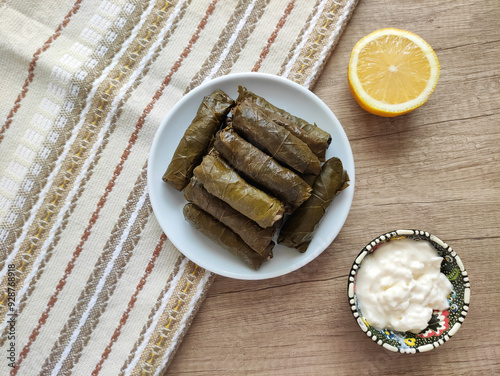 Oriental delicious Turkish dolma made of grape leaves stuffed with rice on a ceramic plate photo
