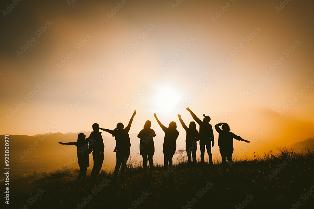 Silhouettes of seven people standing on a hilltop, their arms raised towards the sunset. Silhouettes of seven people standing on a hilltop, their arms raised towards the sunset.