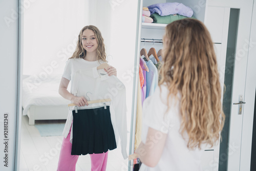 Photo of sweet pretty teen girl choose outfit mirror reflection wear pajama white interior bedroom apartment