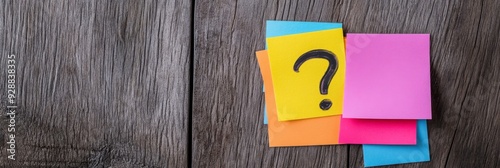Colorful Sticky Notes on a Wooden Background with Question Marks, Conveying the Concept of Inquiry and Planning.