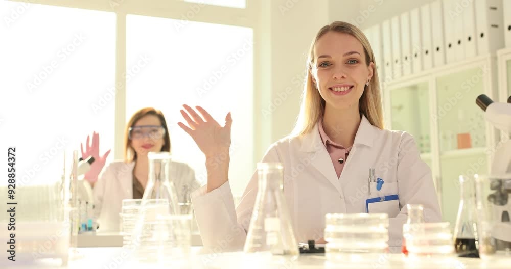 wo scientist in the laboratory waves at camera wo scientist in the laboratory waves at camera