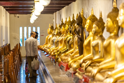 Wat Phra Si Rattana Mahathat Woramahawihan-Phitsanulok: August 9, 2024, Tourists, families with young children, making merit by giving alms in the morning, Mueang District, Thailand photo